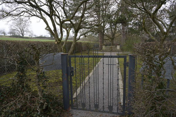 Zauntor am Eingang zur KZ-Friedhofsanlage in Neckargartach, im HIntergrund das Gedenkmal